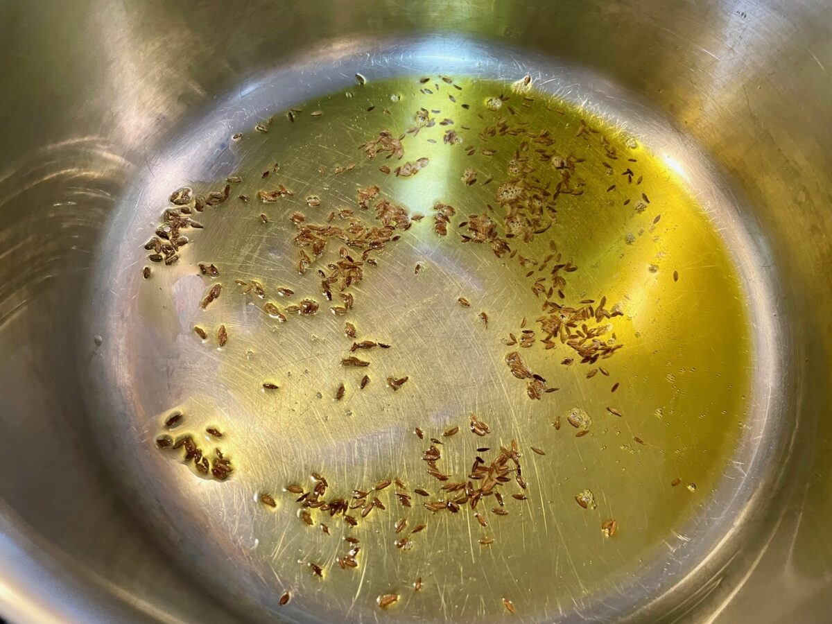 Cumin seeds cooking in pan.