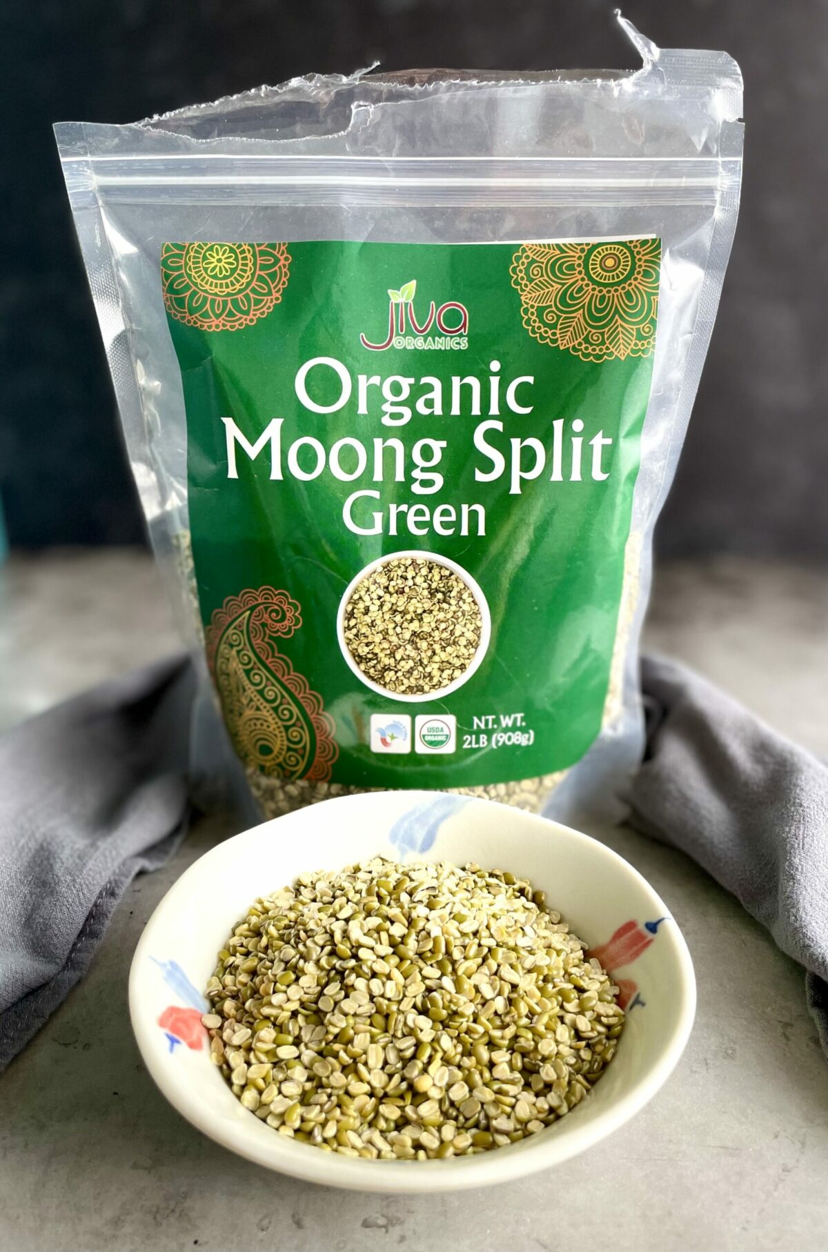 Jiva organic split moong dal (split green mung beans) in packaging and displayed in a small bowl.