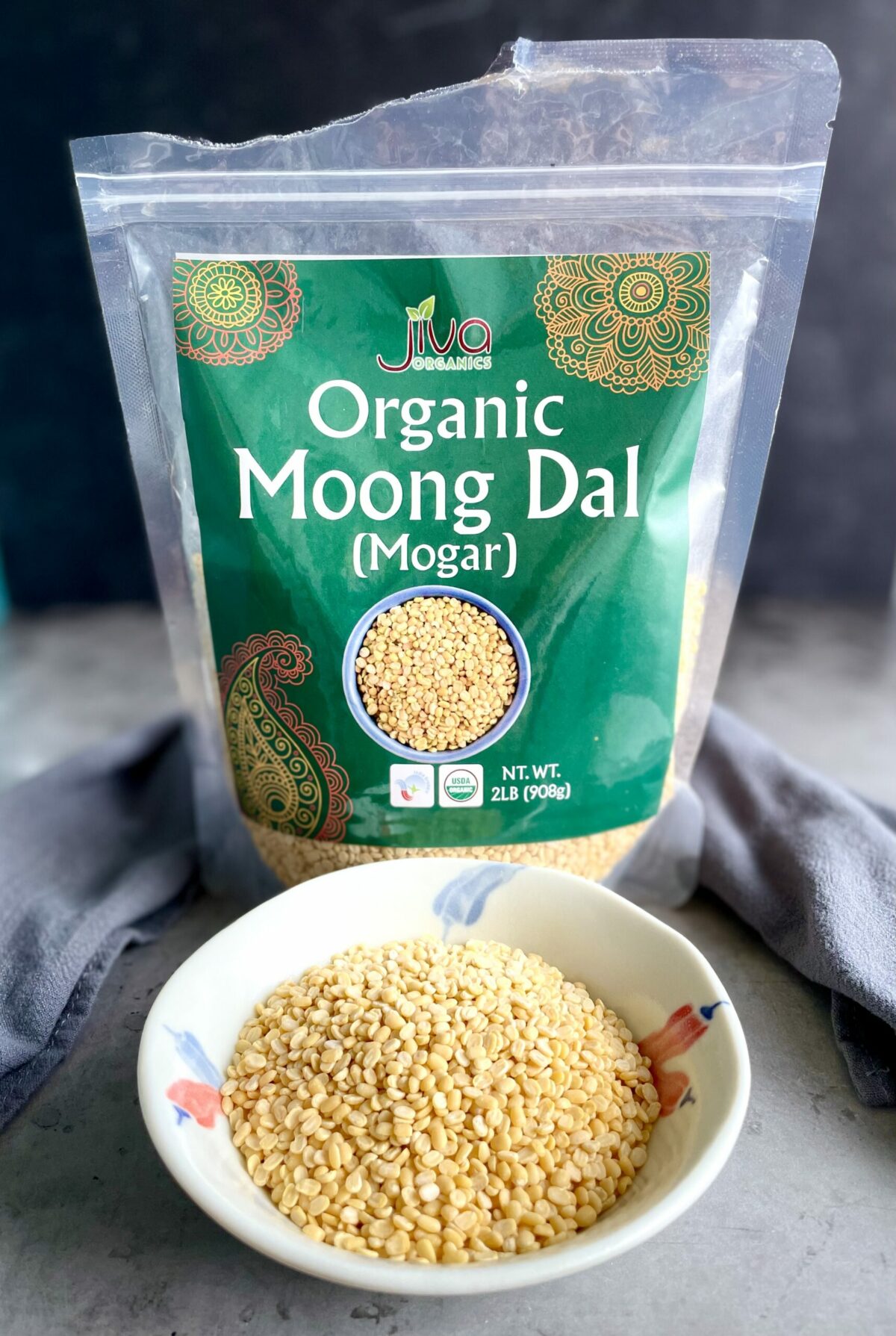 Jiva organic split moong dal (mogar daal) in packaging and displayed in a small bowl.