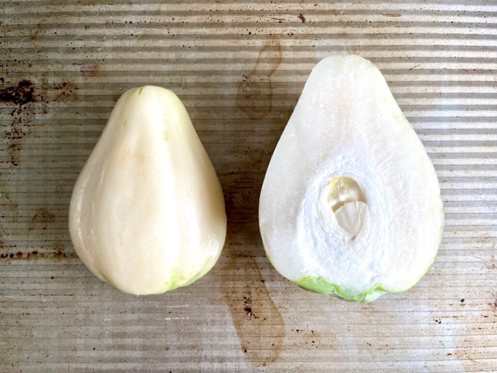White Mexican squash or chayote, cut in half, on oven sheet.